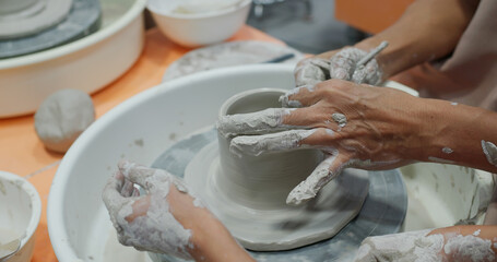 Hand work on pottery wheel, shaping a clay pot