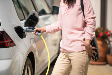 Woman charging electric car 
