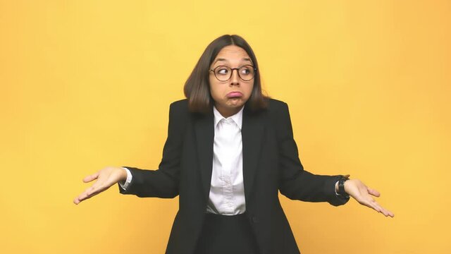 Young business indian woman shrugs shoulders and open eyes confused