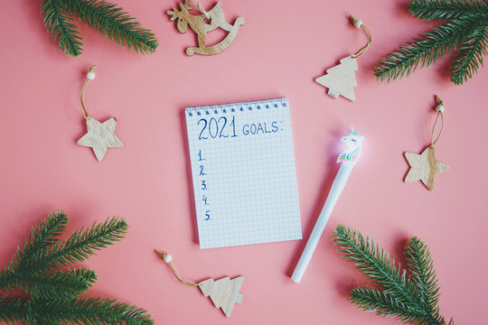Holiday decorations and notebook with 2021 goals, plans, dreams. New Year and Christmas concept. Flat lay. Top view.