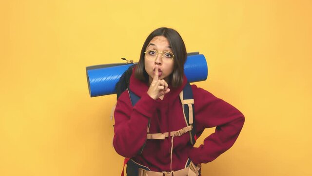 Young hiker indian woman keeping a secret or asking for silence