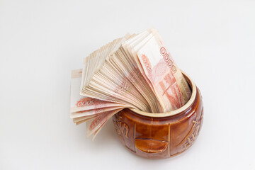 Russian banknotes of five thousand rubles in large quantities in a ceramic pot