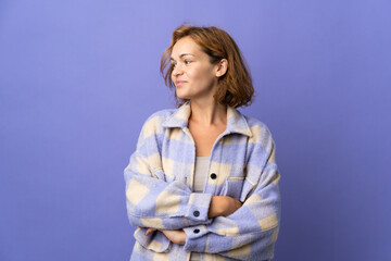 Young Georgian woman isolated on purple background looking to the side