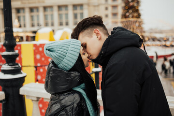 Woman and man enjoying perfect relationships and spending winter vacations on the city street. 