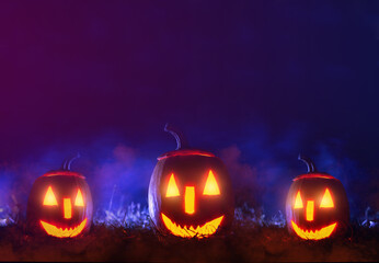 Happy  Halloween day . Halloween pumpkins over blue  background with smoke with  copy space.