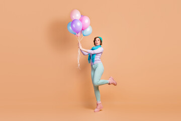 Fototapeta na wymiar Full length body size view of her she nice attractive lovely pretty girlish funny dreamy cheerful cheery girl having fun holding in hands air balls isolated over beige pastel color background