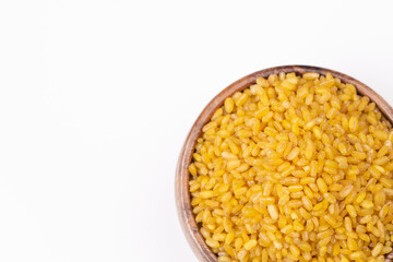 Heap of dry bulgur isolated on white