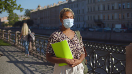 African Female Student with Protective Mask Walking in City Street.