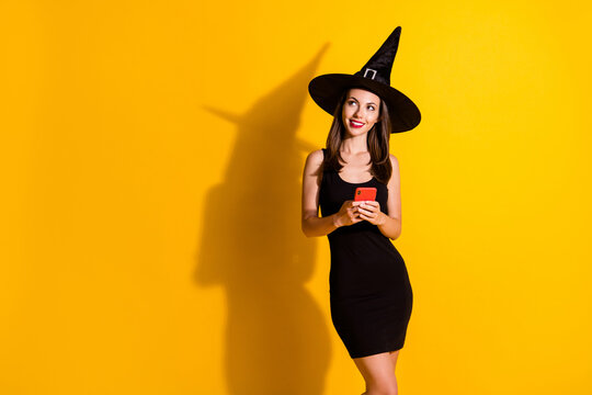 Portrait of her she attractive pretty elegant lovely cheerful dreamy lady wizard using device app 5g creating post smm blogger blogging isolated bright vivid shine vibrant yellow color background