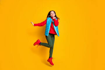 Fototapeta na wymiar Full length photo charming girl jump hold hand send lovely air kiss boyfriend buy present fall season sales wear stylish green blue red sweater boots isolated bright shine color background