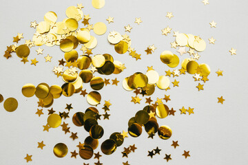 Scattered golden confetti on a white abstract festive background.