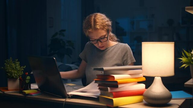 Young woman working with papers at home at night