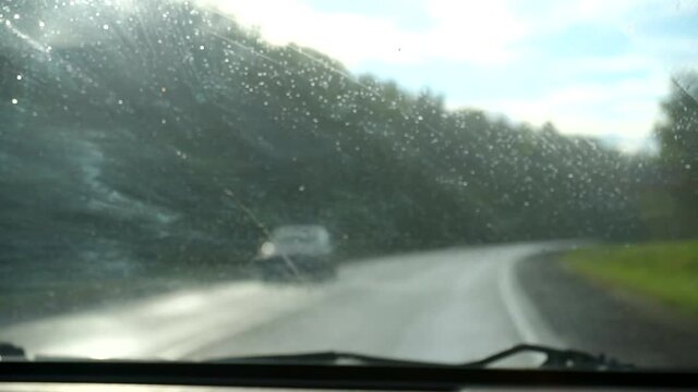 Drive car on traffic street at heavy rain.blurred traffic focus on windshield