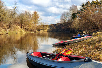 Kayaks on coast of river in early spring. Extreme water entertainment and active. Kayaking on the river.