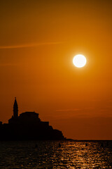 Obraz premium Sonnenuntergang mit Stadt und Bergen im Meer