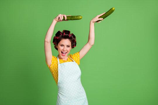 Photo of crazy positive vintage girl cook veggie eco dish meal dance dancer cucumber wear yellow dotted dress skirt hair rollers isolated over green color background