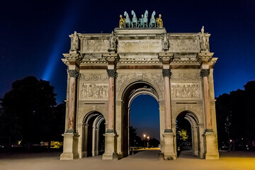 Fototapeta na wymiar Triumphal Arch (Arc de Triomphe du Carrousel) at night in Tuileries gardens in Paris. Monument built between 1806 - 1808 to commemorate Napoleon's military victories. Paris, France.
