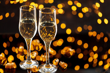 Two glasses of Champagne against bokeh lights background
