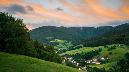 Fototapeta na wymiar Germany, Black Forest Schwarzwald, Glowing red sky above green valley and village in elztal in summer