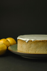  tarta de limón con merengue y limones de decoración sobre un fondo liso color negro