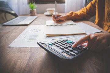  business person sitting at a desk at an office By using the calculator to work. Business Concept...