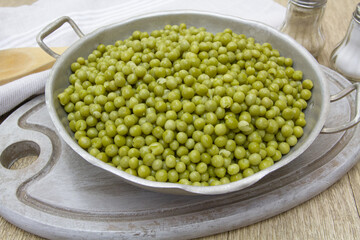 plat de petits pois cuits sur une table en bois