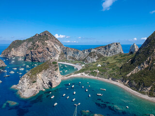 Drone view of Palmarola island with chrystalline green water and boats (Ponza, Latina, Lazio,...