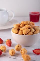 Dried Cookies served on a white bowl with scattered cookies and strawberry jam on the side