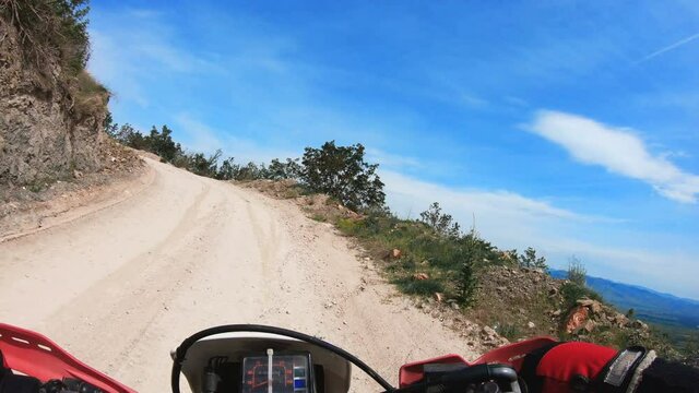 Professional Motocross Motorcycle Rider Drives on the Off-Road Mountain