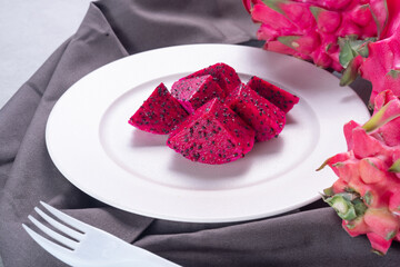 A Plate of dragon fruit served on concrete table.