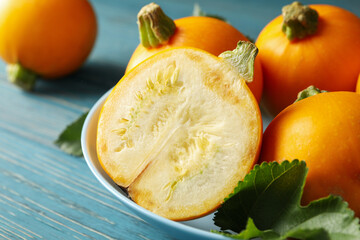 Bowl with round zucchini on wooden table, close up