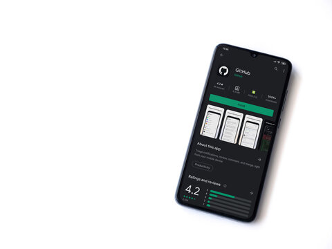Lod, Israel - July 8, 2020: GitHub app play store page on the display of a black mobile smartphone isolated on white background. Top view flat lay with copy space.