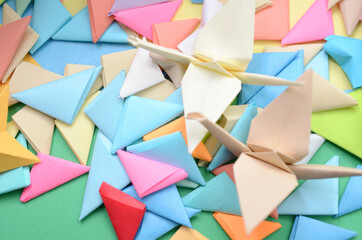 two origami cranes with origami background