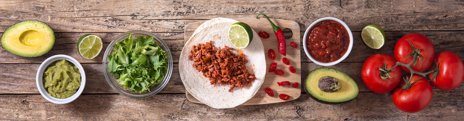 Mexican tacos ingredients on wooden table. Panorama view	