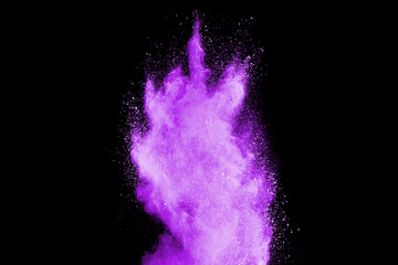Freeze motion of purple color powder exploding on black background.