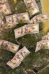 Financial Christmas tree. Festive Xmas tree decorated with hundred US dollars instead of Christmas ornaments