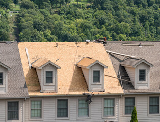 Roofing contractor has removed all the old tiles from townhouse roof before replacing with new shingles © steheap