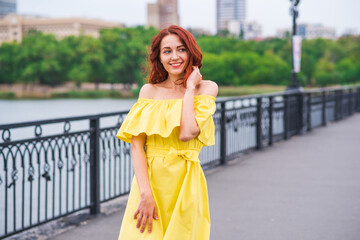 Happy beautiful redhead girl walking in the park