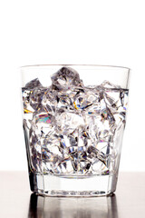 A glass of vodka with ice on a bright white background.