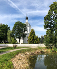 Obraz premium Temple of Boris and Gleb on the shore of the pond in the Belkino Manor in Obninsk. Ð¡hurch next to the pond. Summer landscape.