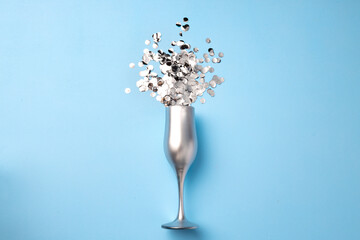 Naklejka na ściany i meble Champagne glass with confetti flat lay top view