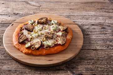 Autumn pumpkin pizza with vegetables on wooden table. Copy space	