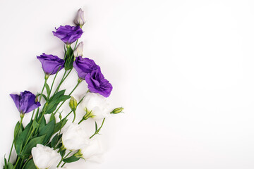 Tender white and purple flowers of eustoma. Flat lay, top view, copy space. Wedding invitation.