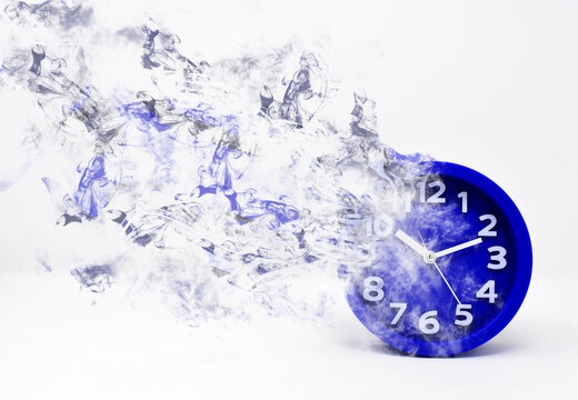El reloj gira y se desvanece en humo. Concepto del paso del tiempo, el tiempo vuela y pasa el tiempo.