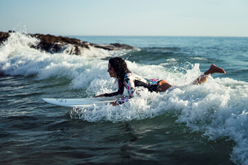 Joven atractiva con tabla de surf practicando en cadiz