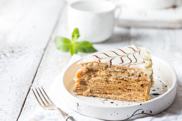 Traditional Hungarian Esterhazy piece of cake on a white wooden background.