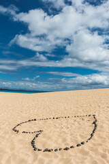 Fototapeta na wymiar Romantico corazon hecho en la arena con rocas volcanicas de la isla de Fuerteventura, Islas Canarias, España