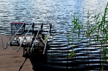 Fototapeta na wymiar Carp fishing rods in the lake. Rods on a rod pod with the swingers attached ready to catch a fish