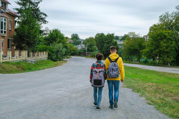 Editorial. Borshchiv, Ternopil region, Ukraine. September 03, 2020. A young couple with backpacks walking down the street. Local tourism. Fortuna Gold Color.