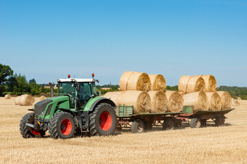 Tractor and two loaded trailers with straw rolls - 3493